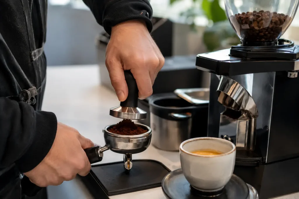 Barista przy ekspresie kolbowym.