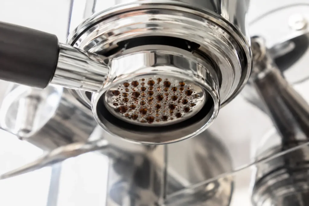 Pierwsze krople espresso pojawiające się pod kolbą podczas wstępnego nasączania kawy